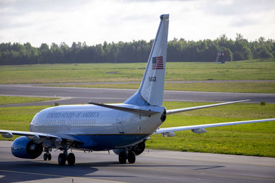 Airplane on airport runway against sky