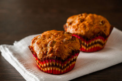 Homemade muffins with raisins on a wooden background. cupcake in a paper mold on a white napkin.