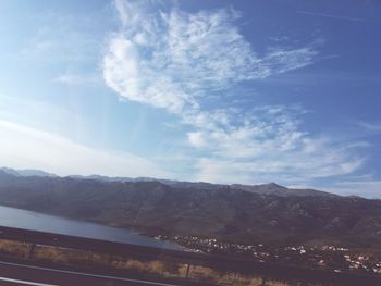 Road by mountains against sky