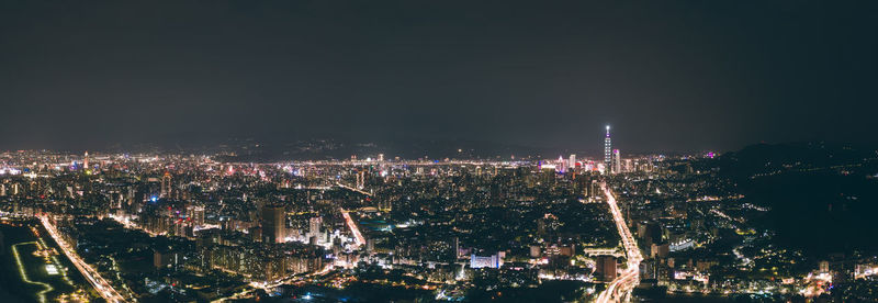 Illuminated city against sky at night