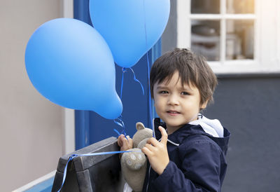 Portrait of cute boy holding balloons