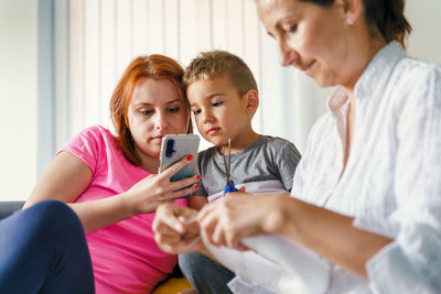 Happy friends sitting on mobile phone