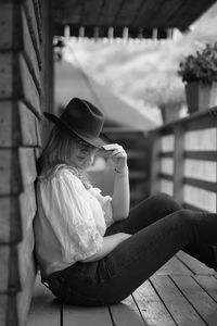 Side view of woman sitting on bench