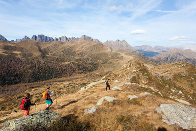 Rear view of people on mountain against sky