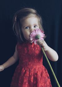 Portrait of cute girl holding red flower