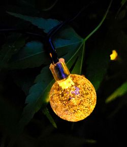 Close-up of illuminated lighting equipment hanging at night