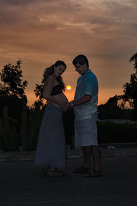 Rear view of couple kissing at night