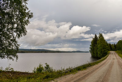 Road by lake against sky