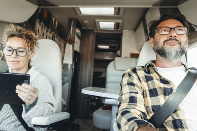 Portrait of young man using mobile phone while sitting in car