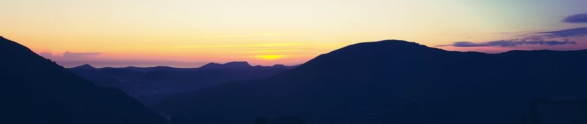 Silhouette of mountain range at sunset