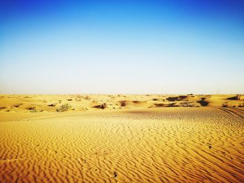 Scenic view of desert against clear blue sky