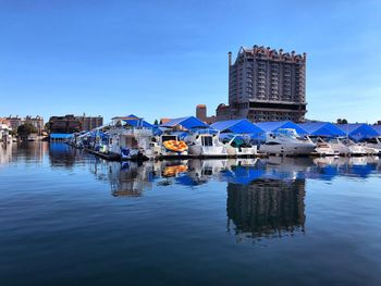 Reflection of buildings in river against blue sky