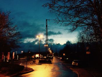 Road passing through city against cloudy sky