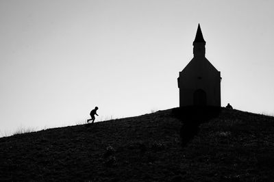 Low angle view of cross on field against clear sky