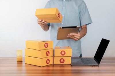 Midsection of man with toy blocks against white background