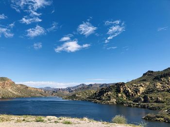 Scenic view of lake and mountains against blue sky