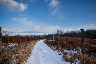 Snow covered land road against sky during winter