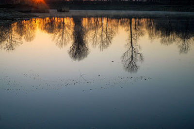 Scenic view of lake against sky at sunset