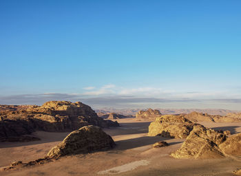 Rock formations on landscape against blue sky