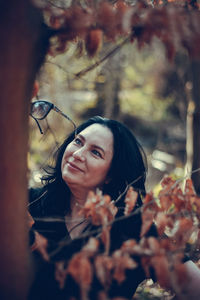 Portrait of young woman with leaves during autumn