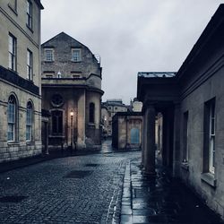 Empty street amidst buildings against sky