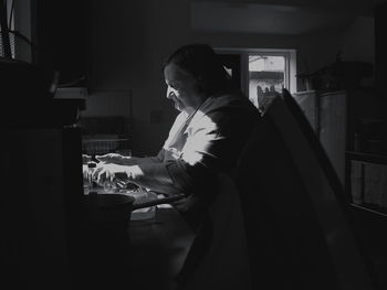 Side view of woman washing dishes at home