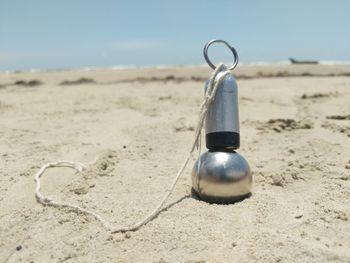 Close-up of metallic object on beach