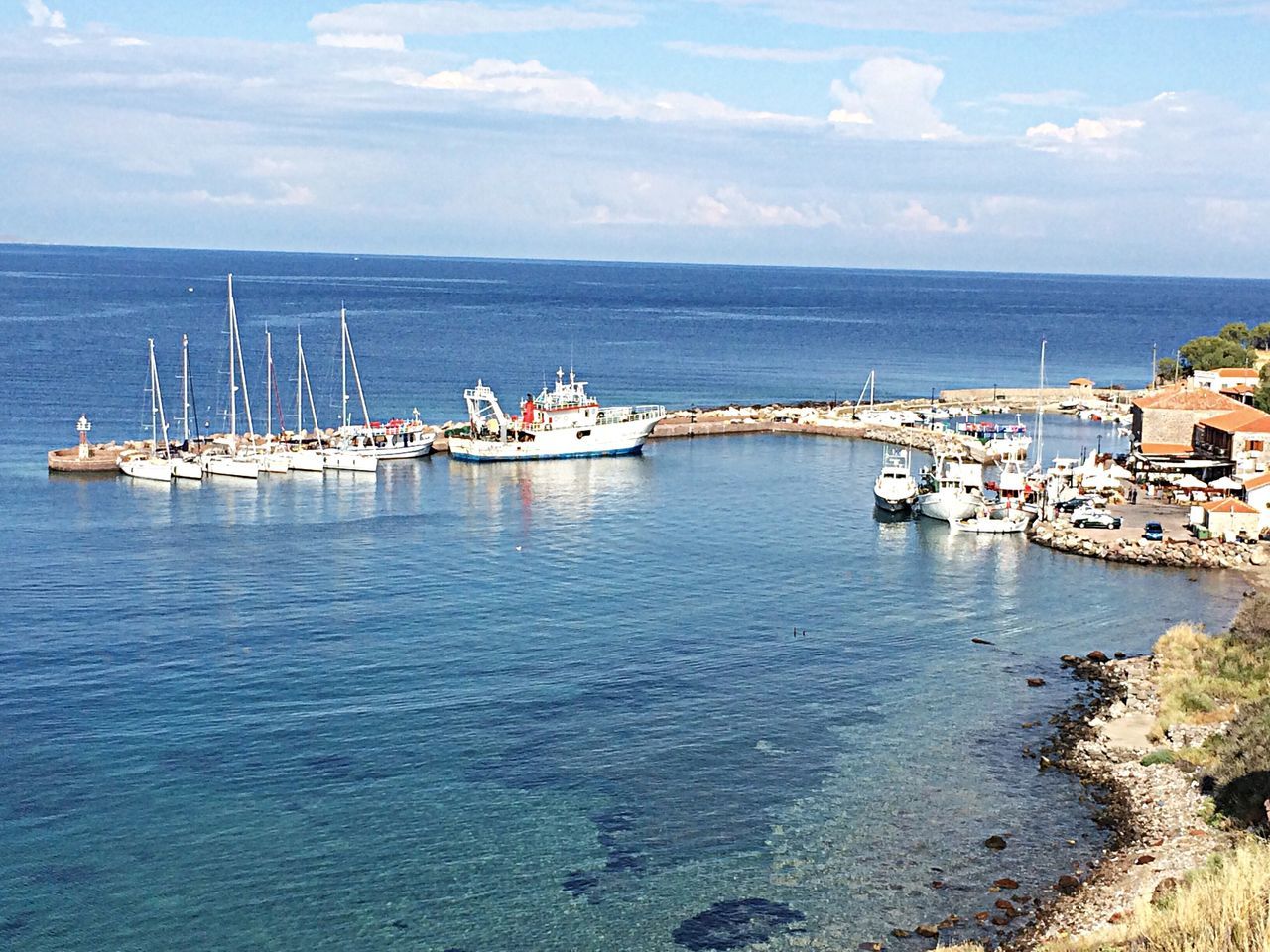 sea, water, nautical vessel, sky, horizon over water, boat, transportation, mode of transport, moored, harbor, blue, tranquility, cloud, tranquil scene, nature, cloud - sky, day, waterfront, built structure, outdoors