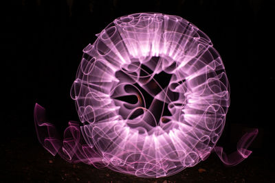 Close-up of illuminated lighting equipment against black background