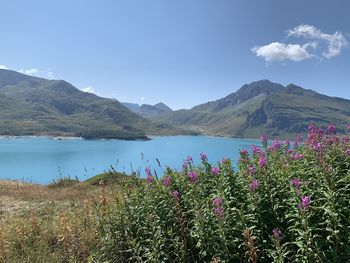 Scenic view of lake by mountains against sky