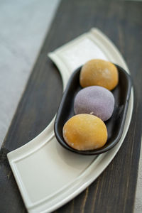 Multi-colored japanese mochi in rice dough and on a wooden background. traditional japanese dessert.