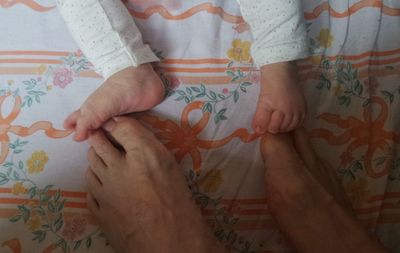 Low section of people on bed at home