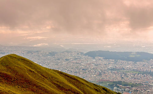 Aerial view of city by sea against sky