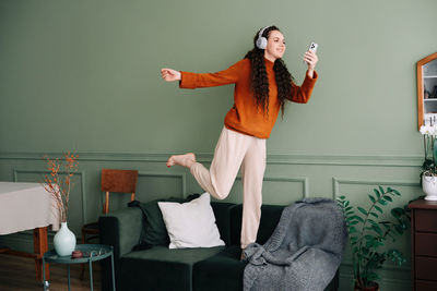 Portrait of young woman sitting on sofa at home