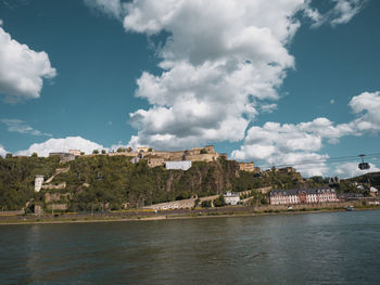 Scenic view of sea by buildings against sky