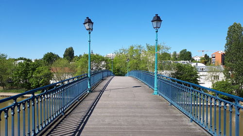 Footbridge over street against clear sky