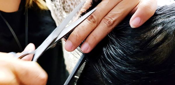 Close-up of person cutting hair 