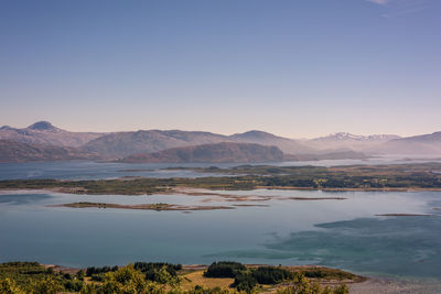 Scenic view of lake against clear blue sky