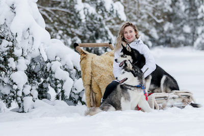 Woman with dog on snow covered field