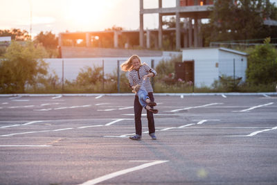 Full length of woman standing on road in city