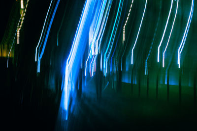 Blurred motion of silhouette trees against sky at night