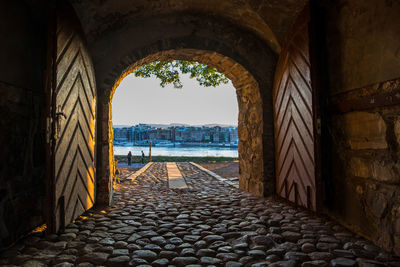 View of historic building against sky seen through arch