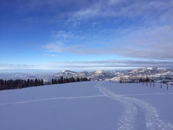 Scenic view of snowcapped mountains against blue sky