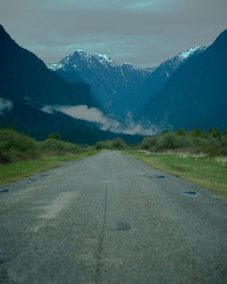 Road amidst snowcapped mountains against sky