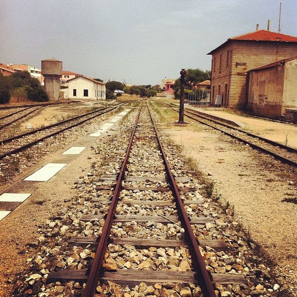 railroad track, rail transportation, transportation, the way forward, built structure, diminishing perspective, architecture, building exterior, vanishing point, public transportation, railway track, clear sky, sky, day, outdoors, high angle view, railroad station platform, railroad station, straight, surface level