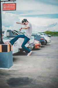 Full length of young man jumping on street in city