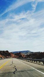 Road leading towards city against sky