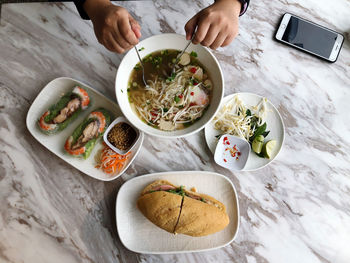 High angle view of hand holding food on table