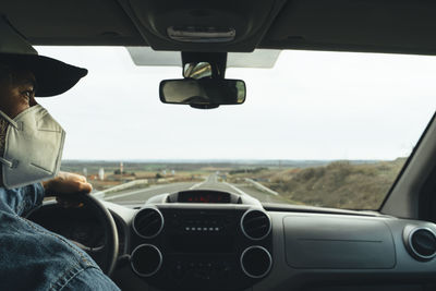 Man seen through car windshield