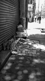 Man on footpath by street in city